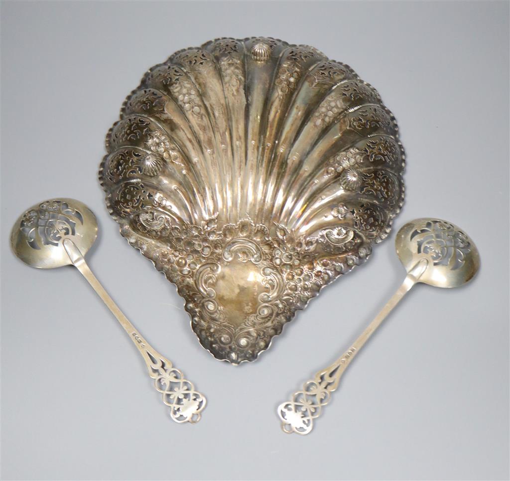 An Edwardian silver embossed and pierced scallop shaped dish, 28.3cm, Sheffield, 1905 and a pair of pierced silver spoons,12.5oz.